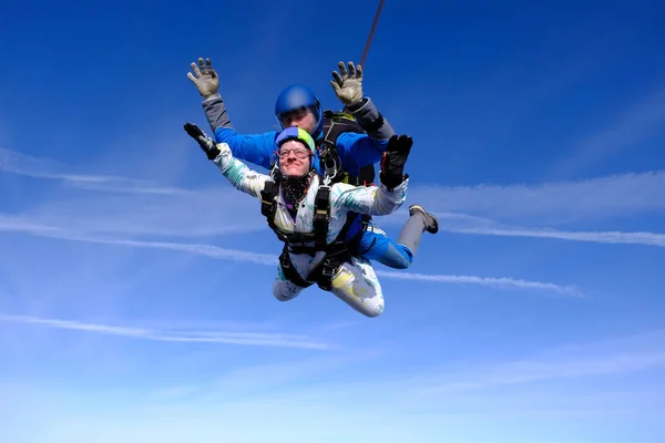 Skydiving. Tandem jump. People in the sky. A man and a woman are flying together.
