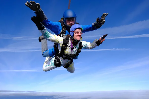 Skydiving. Tandem jump. People in the sky. A man and a woman are flying together.