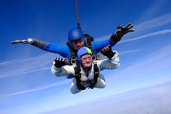 Skydiving. Tandem jump. People in the sky. A man and a woman are flying together.