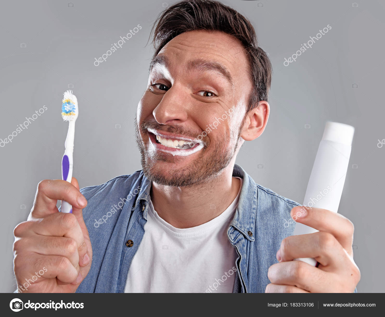Handsome bearded man isolated on a white background with a douche bag in  his hand. Guy holding blue douche is concerned about expensive medicine but  he wants to be healthy again. Stock