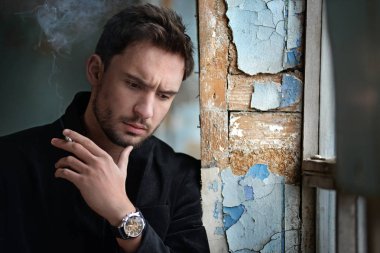 Sinsi göz gizemli yakışıklı adam. Sakal gülümseyen adam. emin yüz karanlık bir ceketle seksi adam. Güzel gözlü seksi ve akıllı adam. işadamı karanlık romantik arka plan üzerinde.