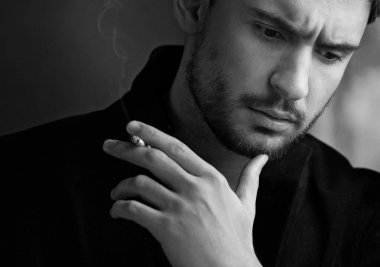 Sinsi göz gizemli yakışıklı adam. sakal gülümseyen adam. emin yüz karanlık bir ceketle seksi adam. Güzel gözlü seksi ve akıllı adam. Sigara içilmeyen bir romantik koyu arka plan üzerinde işadamı