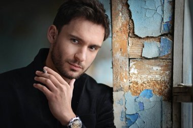 Sinsi göz gizemli yakışıklı adam. sakal gülümseyen adam. emin yüz karanlık bir ceketle seksi adam. Güzel gözlü seksi ve akıllı adam. Sigara içilmeyen bir romantik koyu arka plan üzerinde işadamı