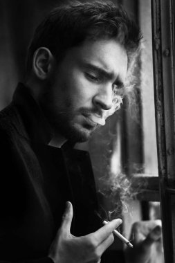 Sinsi göz gizemli yakışıklı adam. sakal gülümseyen adam. emin yüz karanlık bir ceketle seksi adam. Güzel gözlü seksi ve akıllı adam. Sigara içilmeyen bir romantik koyu arka plan üzerinde işadamı