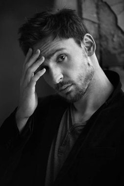 Sinsi göz gizemli yakışıklı adam. sakal gülümseyen adam. emin yüz karanlık bir ceketle seksi adam. Güzel gözlü seksi ve akıllı adam. Sigara içilmeyen bir romantik koyu arka plan üzerinde işadamı