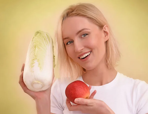 Beautiful healthy vegan blonde woman with blue eyes and red lips in a white t shirt holdind vegetables in her arms, a red apple and a cabbage with different expressions (surprised, happy, sad and in love)