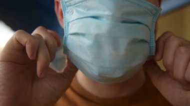 Cerrahi maskeli bir adam boş stadyumda duruyor. Adam maskesini takıyor ve parmaklarını ağıza uzatıp öksürüyor. Koronavirüsün salgın virüs hastalığından korunmak için maske takmasından korkuyorlar..