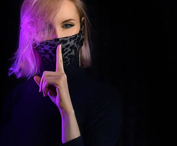 neon lights woman in surgical mask against coronavirus poses for fashion luxury shot, infected girl scared of epidemic disease covid-19 virus wearing mask, patient in mask isolated in black background