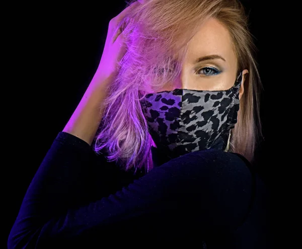 neon lights woman in surgical mask against coronavirus poses for fashion luxury shot, infected girl scared of epidemic disease covid-19 virus wearing mask, patient in mask isolated in black background