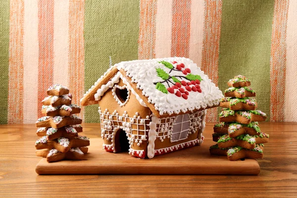 Gingerbread house in the glaze with gingerbread trees, Christmas baking