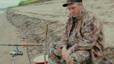 Nehrin üzerinde iplik iplik katlanan sandalyede otururken balıkçı atar  