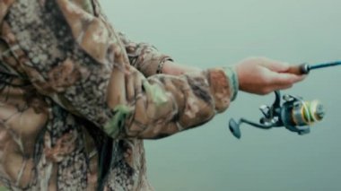 Balıkçının el atmak iplik ve büküm nehir kıyısında bobin Close-Up eller 