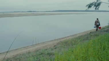 Balıkçı nehir kıyısında yürüyen bir balıkçı genel planı yolda 