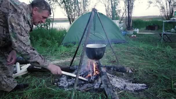 Un pescador junto al fuego — Vídeos de Stock