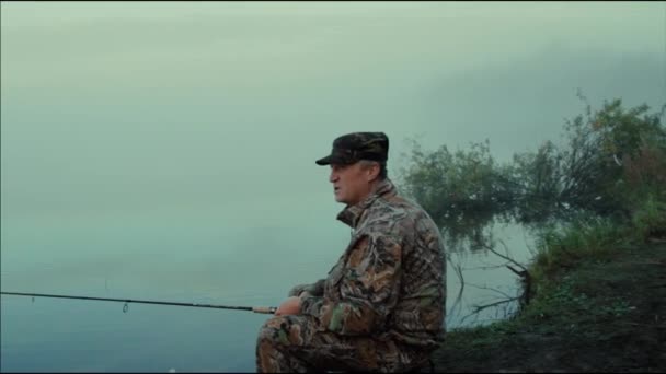霧の朝の湖のほとりにクローズ アップを回転と回転して漁師の男 — ストック動画