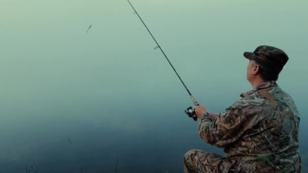 家伙与纺纱渔民与纺纱特写在湖岸边的一个雾的早晨 — 图库视频影像