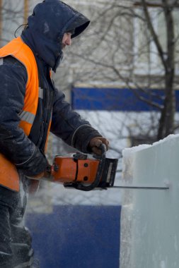 İşçi, buz panelini benzin testeresiyle kesti