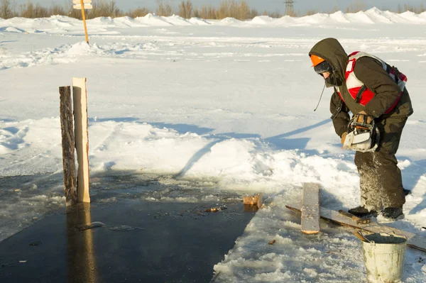 Worker with a chainsaw in the hands of an ice hole — Stock Image Worker with a chainsaw in the hands of an ice hole Royalty Free Stock Images