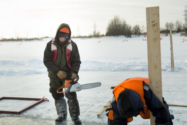 İşçiler buz deliği için formları topluyorlar.