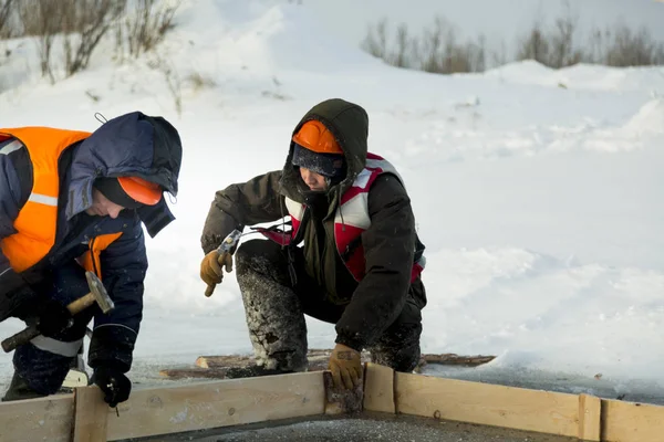 Workers collect the formwork for the ice hole — Stock Image Workers collect the formwork for the ice hole Royalty Free Stock Photos