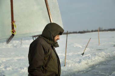 Kapüşonlu yeşil ceketli bir işçinin portresi