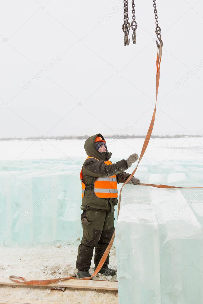 Slinger in orange helmet on shipment of ice blocks