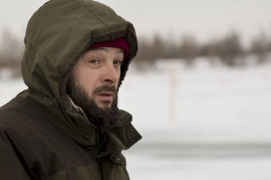 Kapüşonlu yeşil ceketli bir işçinin portresi