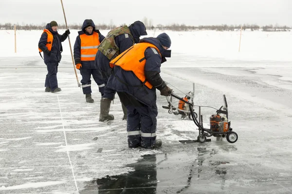 Рабочие разрезают ледяные блоки до размера льда на замерзшем озере — стоковое фото