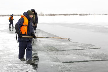 İşçi salları donmuş bir göle oyulmuş bir kanal boyunca buz blokları
