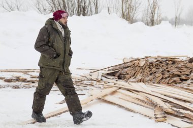 Kırmızı örgü şapkalı işçi toplantı alanında yürüyor.