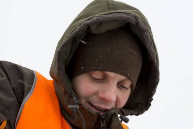 Kapüşonlu yeşil ceketli bir işçinin portresi