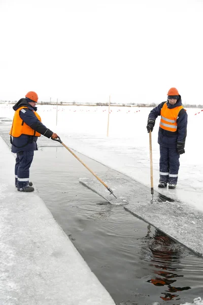 Trabajadores rafting bloques de hielo a lo largo de un canal cortado por un lago congelado —  Fotos de Stock