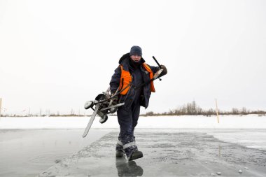 Donmuş bir gölün üzerindeki testere makinesi.