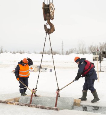 İşçiler yolda buz tutuyorlar.