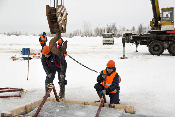 Workers catch ice blocks in the lane