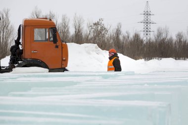 Buz kalıplarının arka planında turuncu bir miğfer takan fırlatıcı.