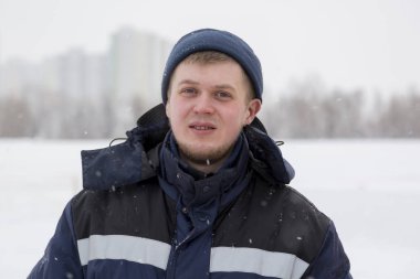 Donmuş bir nehrin buzunda bir işçinin yakın plan portresi.