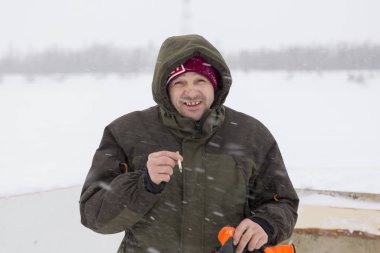 Elinde sigara olan bir tesisatçının portresi.