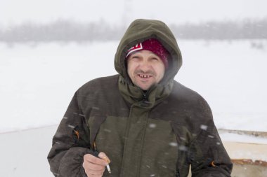 Elinde sigara olan bir tesisatçının portresi.