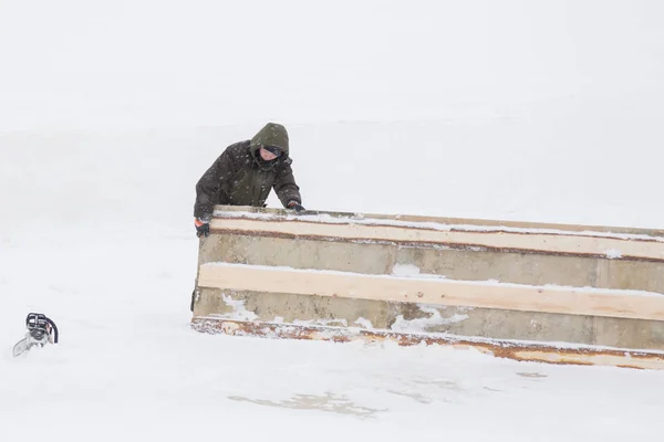 工人们在冬天的工作服上拖着一块木盾牌 — 图库照片