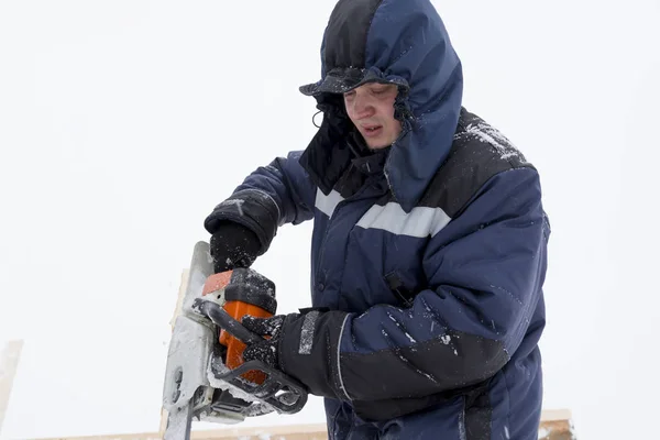 Portret van een assembler met een kettingzaag in zijn handen — Stockfoto