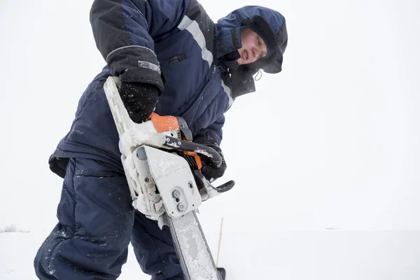 Porträt eines Monteurs mit einer Kettensäge in der Hand — Stockfoto