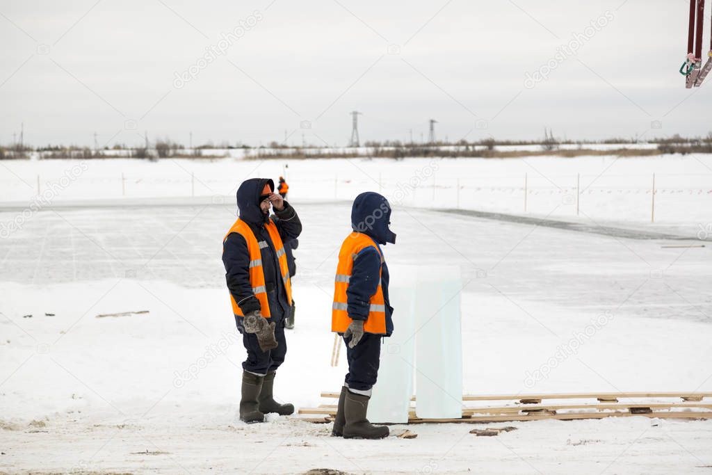 Slingers in special winter overalls for shipment of ice blocks