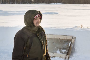 Başında kapüşonlu koruyucu iş elbisesi olan bir işçinin portresi.