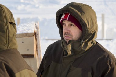 Başında kapüşonlu koruyucu iş elbisesi olan bir işçinin portresi.