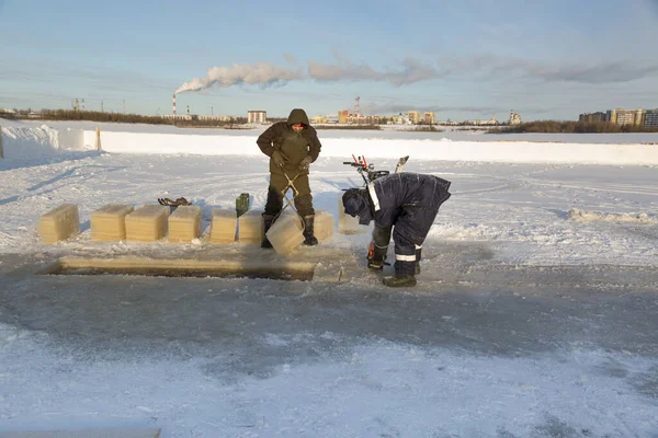 Arbeiter schneidet mit einer Benzinsäge das Eis — Stockfoto