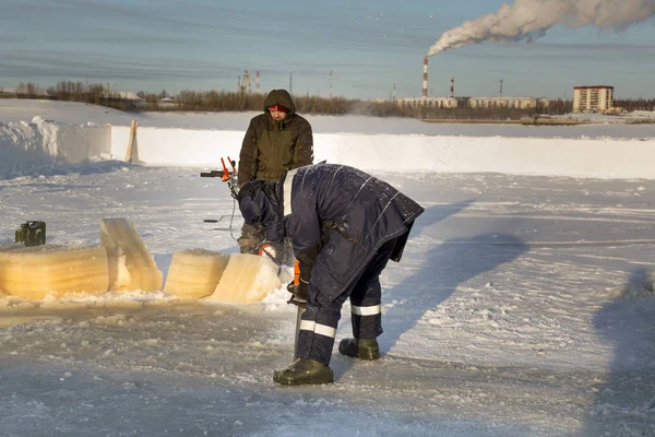 Arbeiter schneidet mit einer Benzinsäge das Eis — Stockfoto