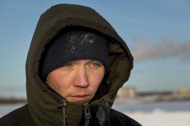 Başında kapüşonlu koruyucu iş elbisesi olan bir işçinin portresi.