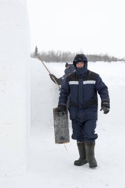 İnşaat alanında elinde fırçayla bir montajcı.