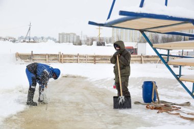 Worker cuts the ice with a gasoline saw
